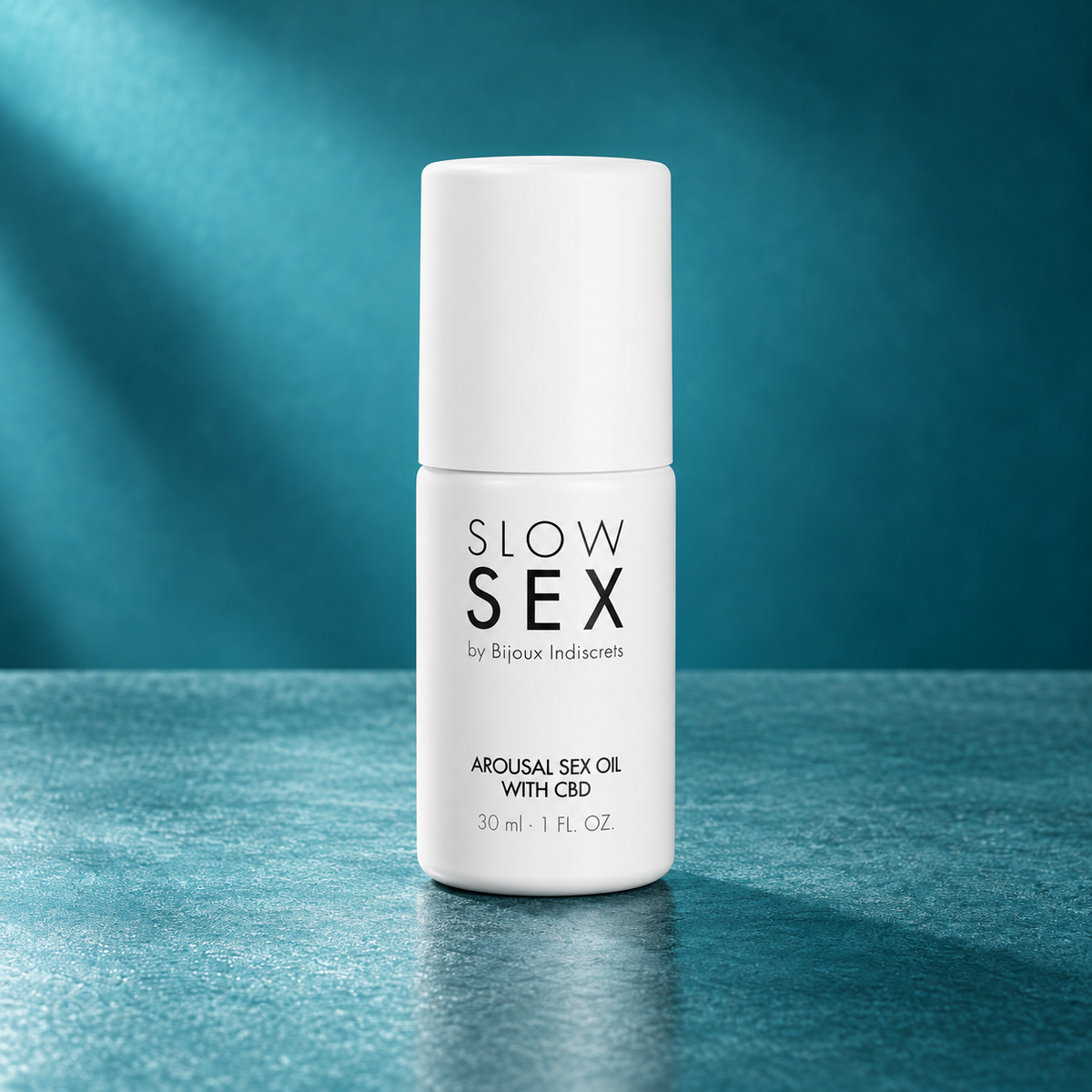 Bijoux Indiscrets Slow Sex CBD oil on teal background
