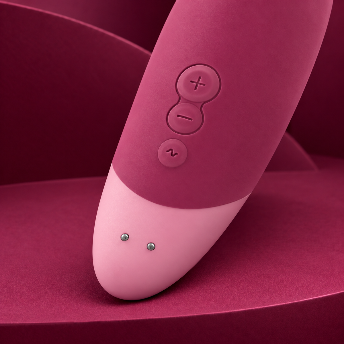 Womanizer Vibe Dusky Pink rear control and charging detail on red geometric background