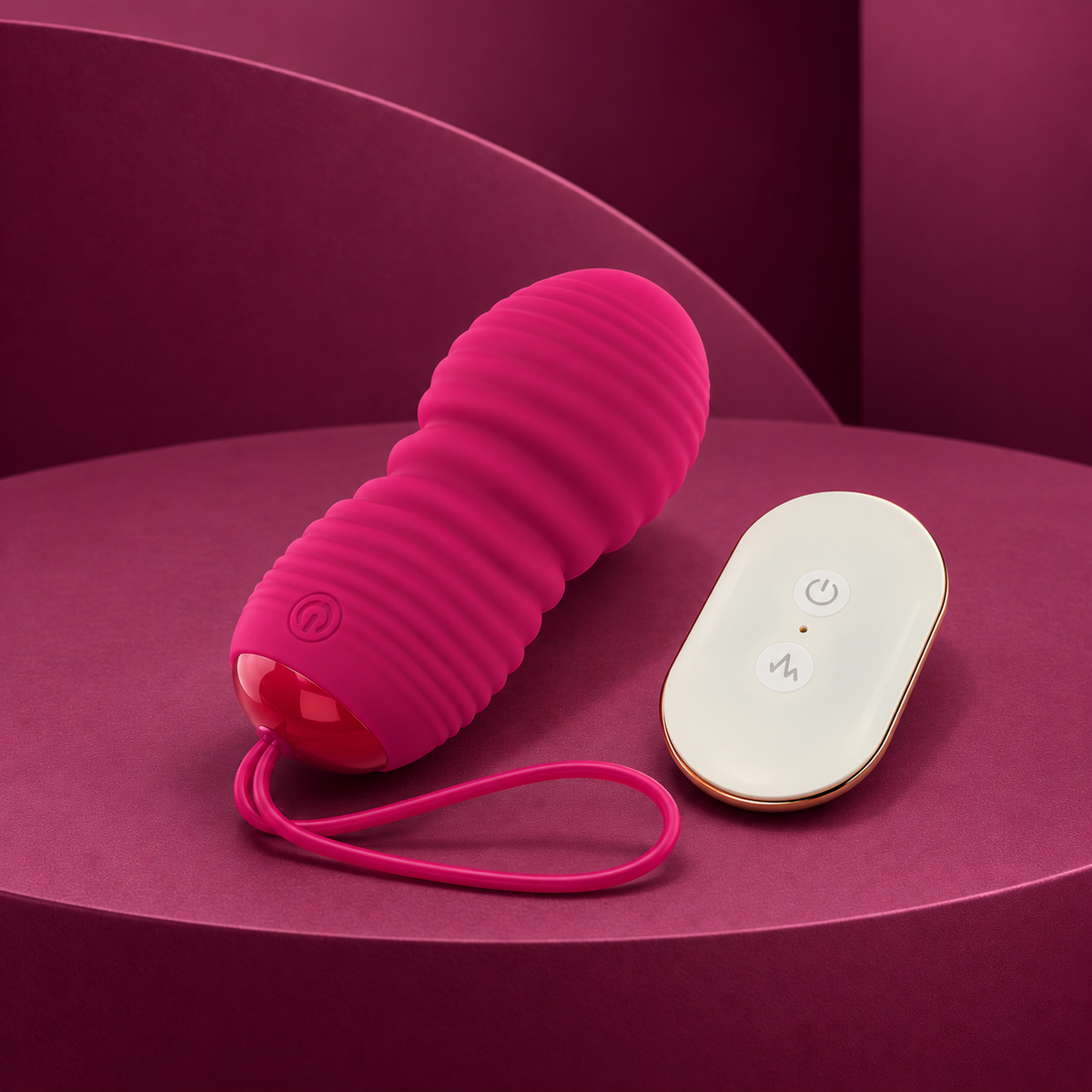 Ohmama pink ribbed vibrating egg with loop and white gold two-button remote on red geometric background